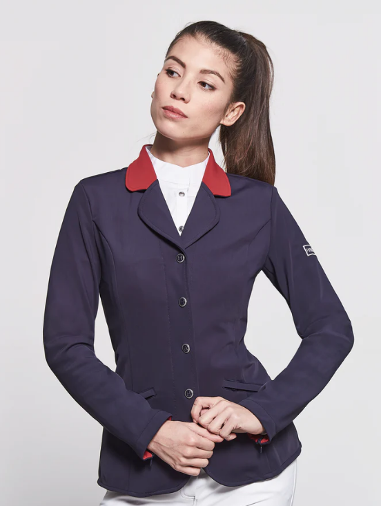 Woman wearing a navy riding jacket with red collar on a white background
