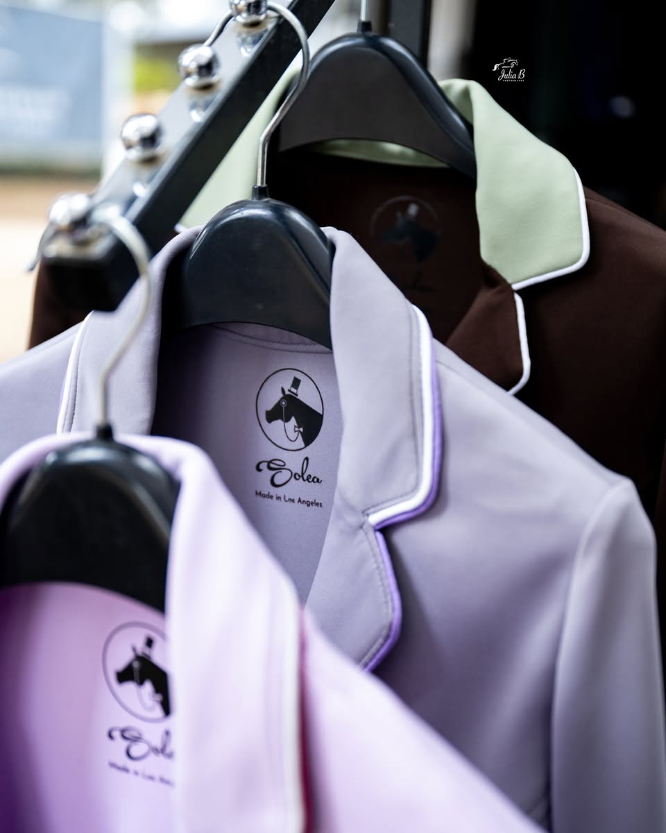 Coats hanging on a rack with a visible brand logo.