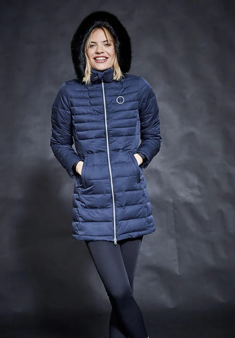 Woman wearing a blue puffer coat against a dark background