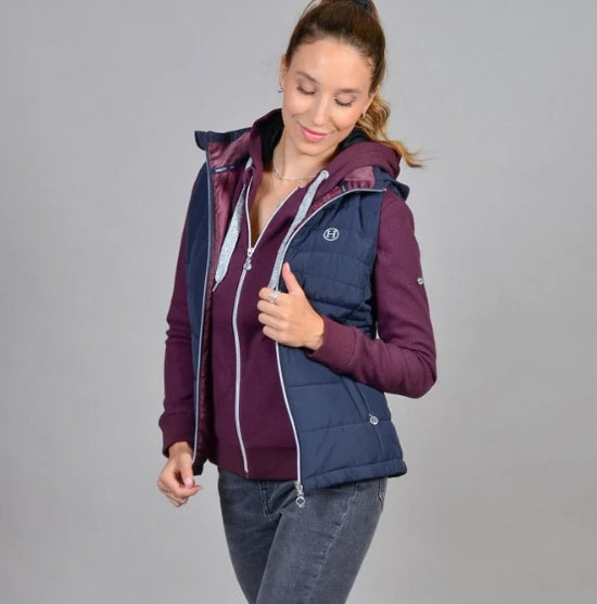 Woman wearing a two-tone purple and navy vest on a gray background