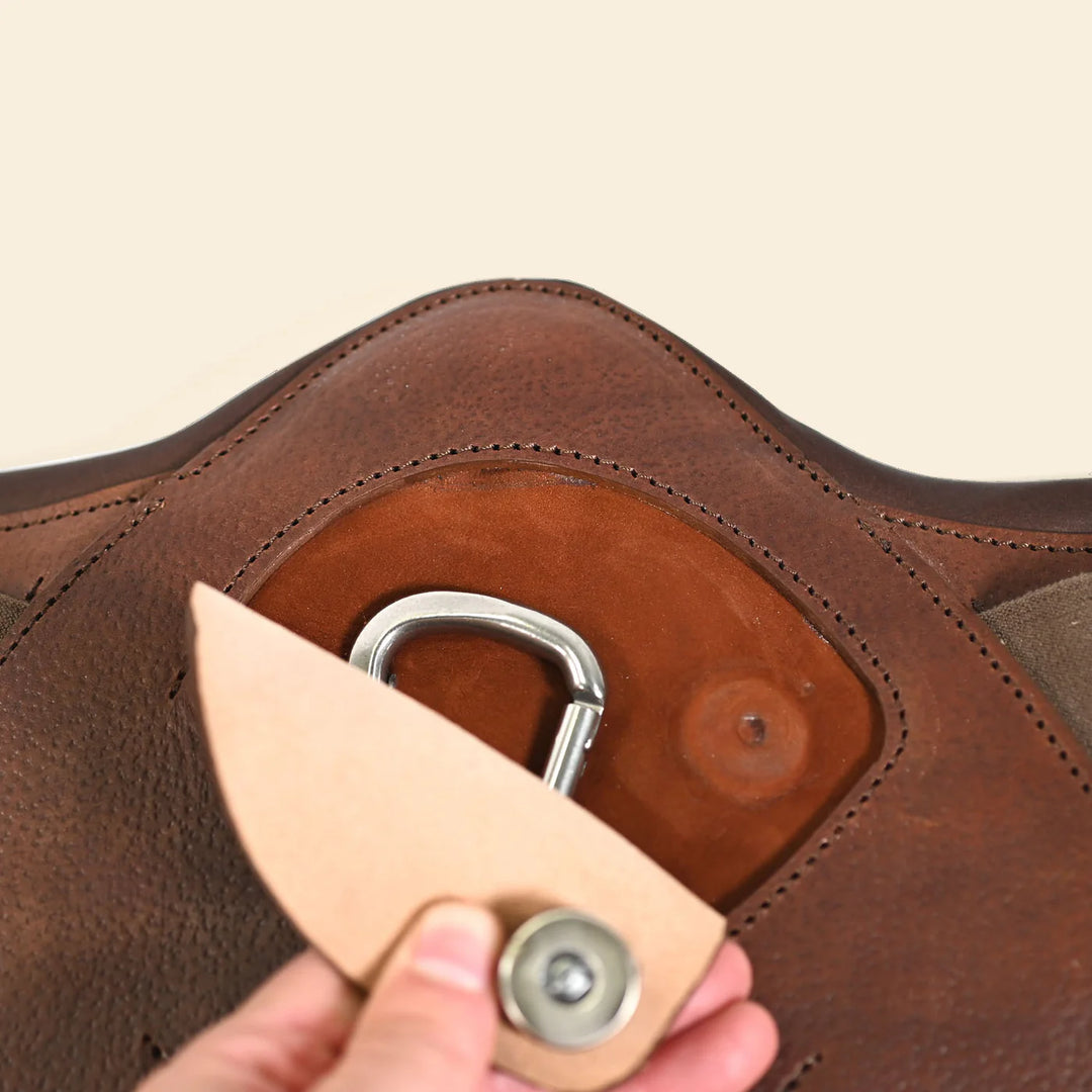Person using a leather tool on a brown leather product