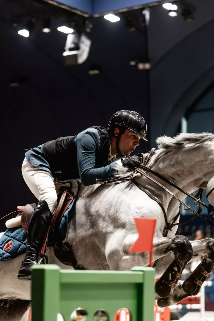 Equestrian rider jumping over an obstacle during a competition.